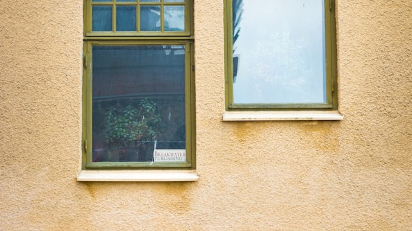 brown coloured uPVC windows on the wall of a yellow building